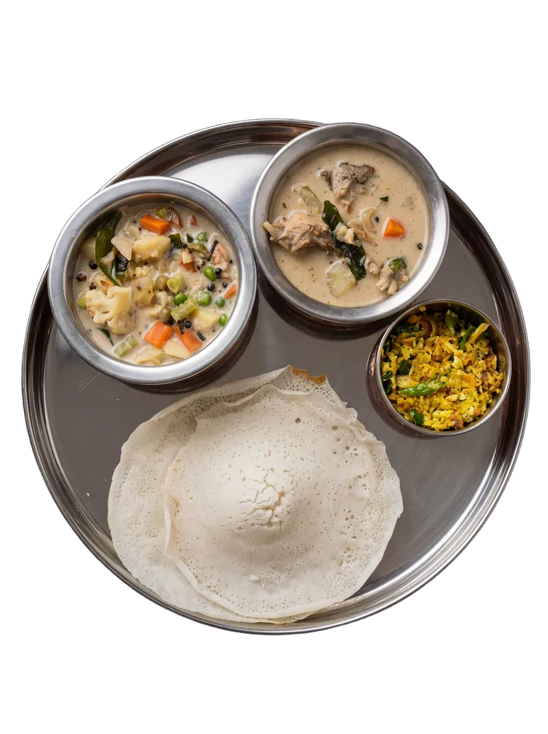 Kerala appam served with white coconut milk vegetable stew in a brass-handled kadai