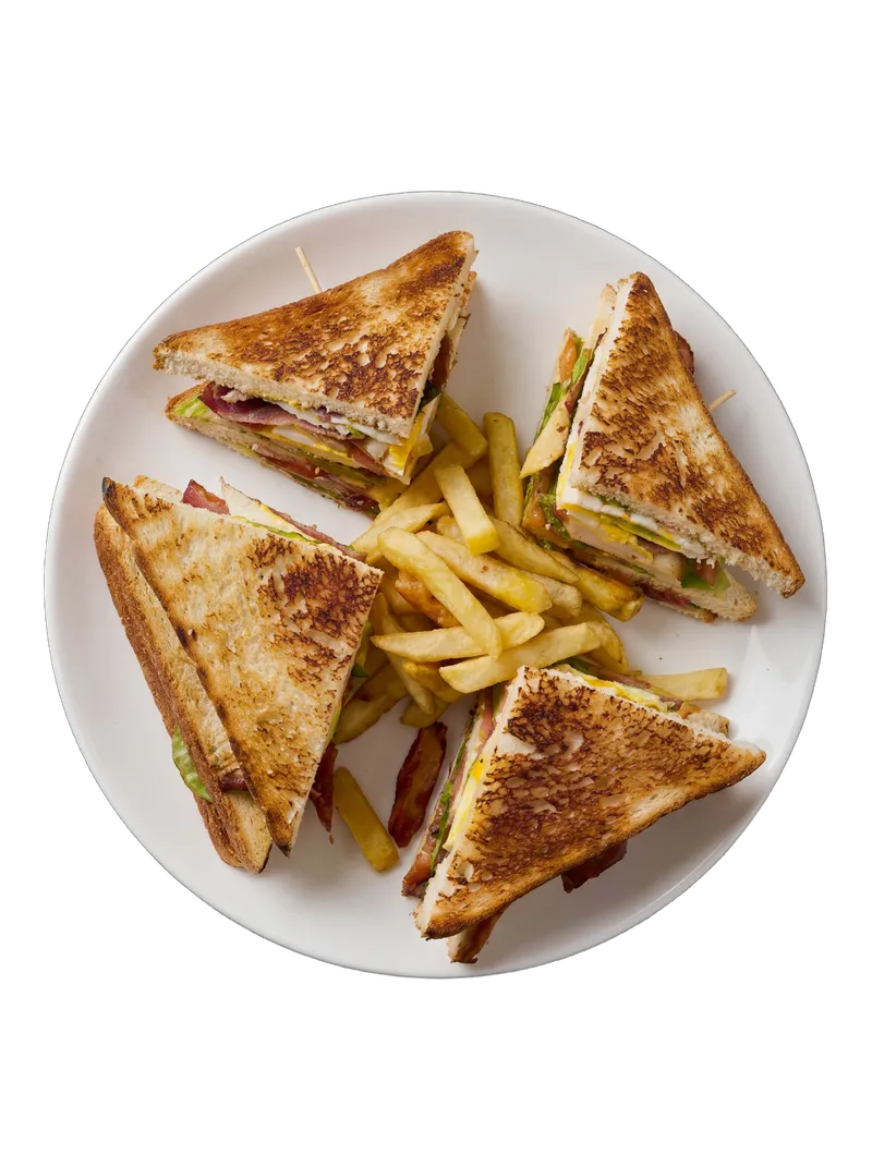 Triple-decker club sandwich with fries on a white plate