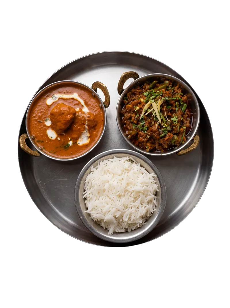 Steamed rice with curry and accompaniments on a steel plate