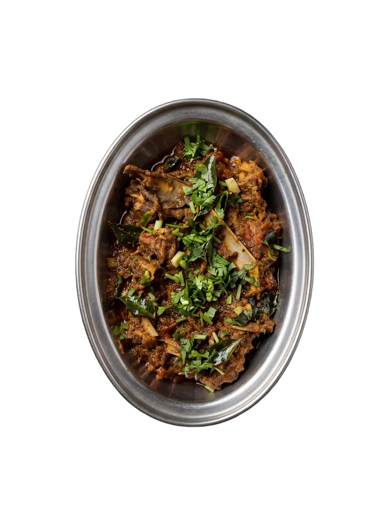 Dry mutton fry with roasted spices and curry leaves on a steel plate