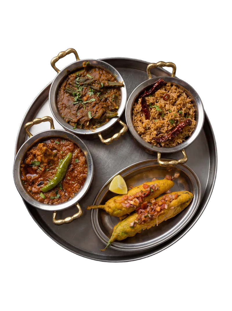 Full Indian thali with 3 bowls, parathas, puri, and rice on a steel plate