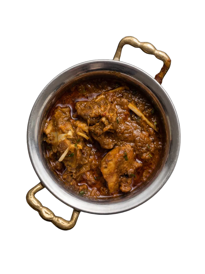 Home-style mutton curry with potato in a brass-handled steel bowl