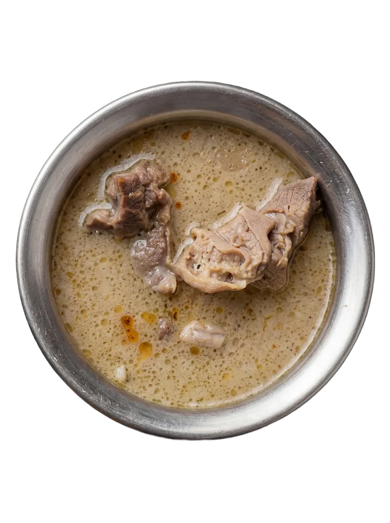 Mutton paya — trotters slow-cooked in a milky gelatin-rich broth on a steel plate