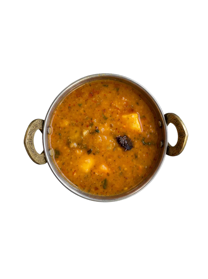 Sambar — South Indian lentil stew with vegetables on a white plate