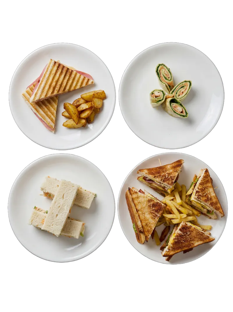 Assorted sandwich platter with grilled ham, pinwheel rolls, tea sandwich, and club sandwich with fries